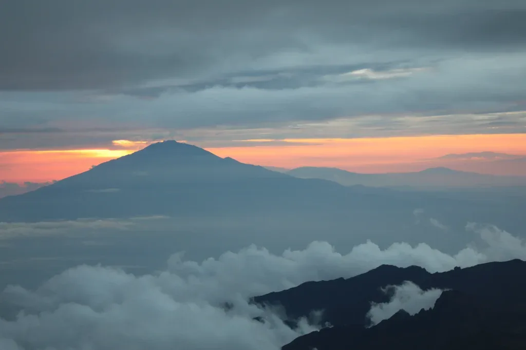 Mountain silhouette beneath an orange evening sky
